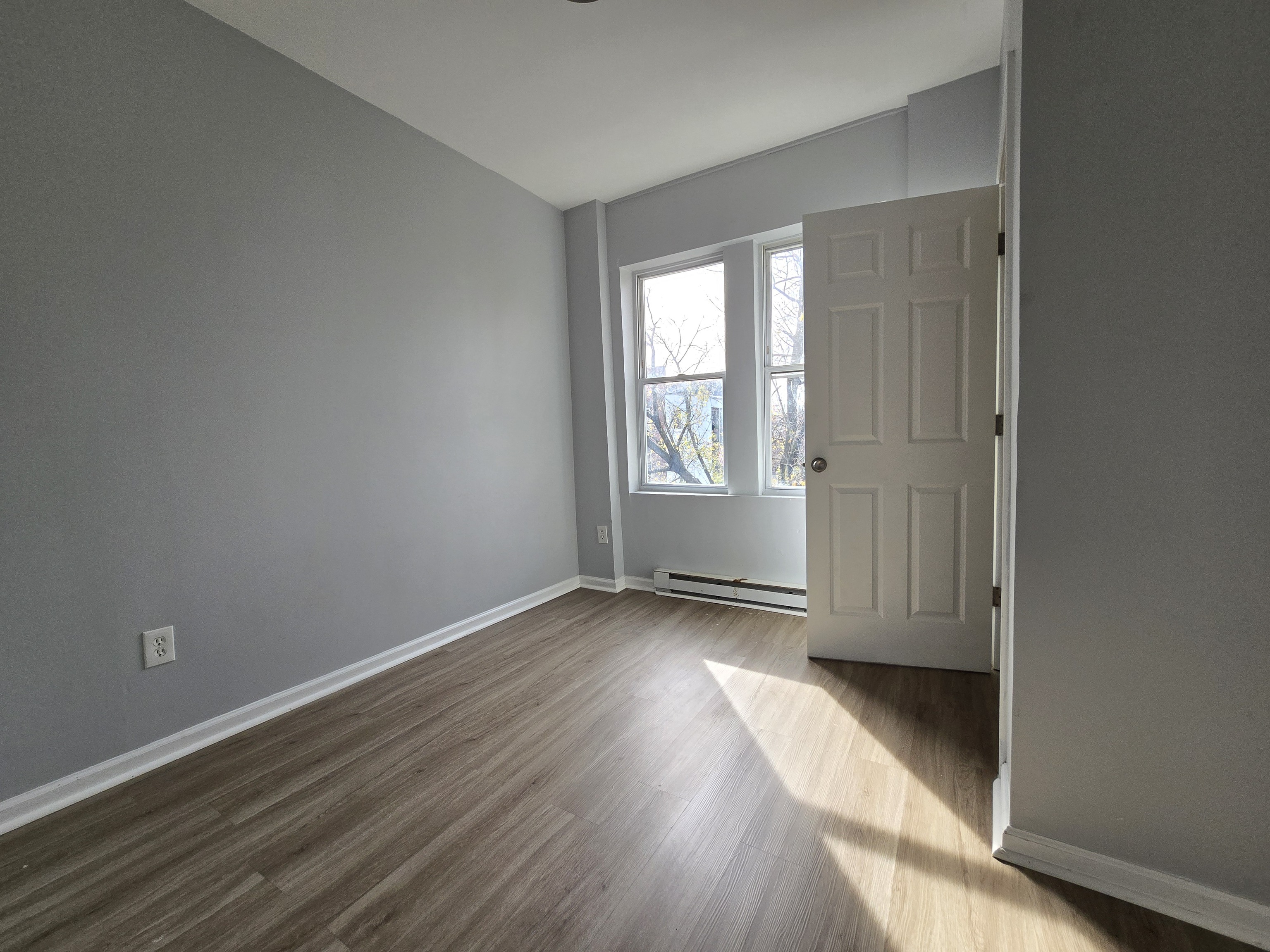 31 Whittier Street, Unit 3B Bridgeport, CT 06605 - Photo 5 of 5 an empty room with wooden floor and windows