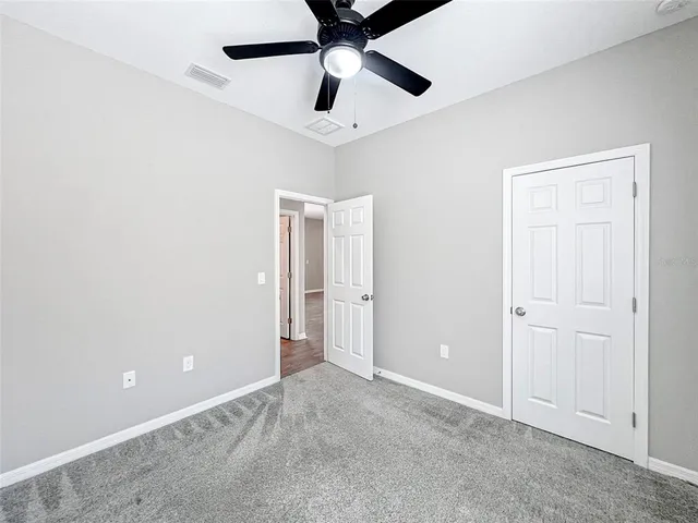 an empty room with chandelier fan