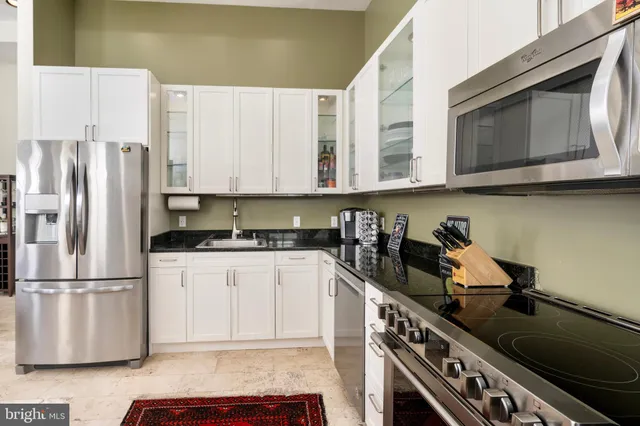 a kitchen with stainless steel appliances granite countertop a stove a sink and a refrigerator