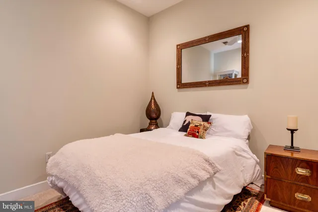 a bedroom with a bed and a lamp on the dresser