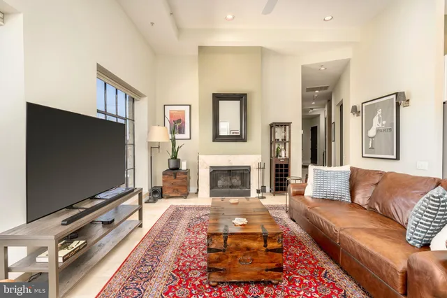 a living room with furniture a flat screen tv and a fireplace
