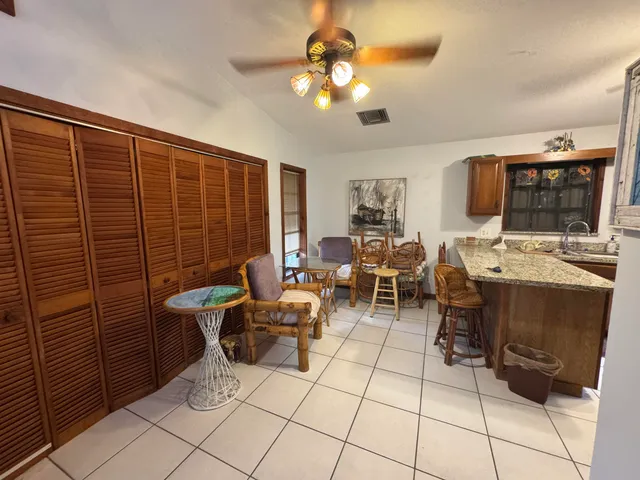 a living room with couches a flat screen tv and kitchen view