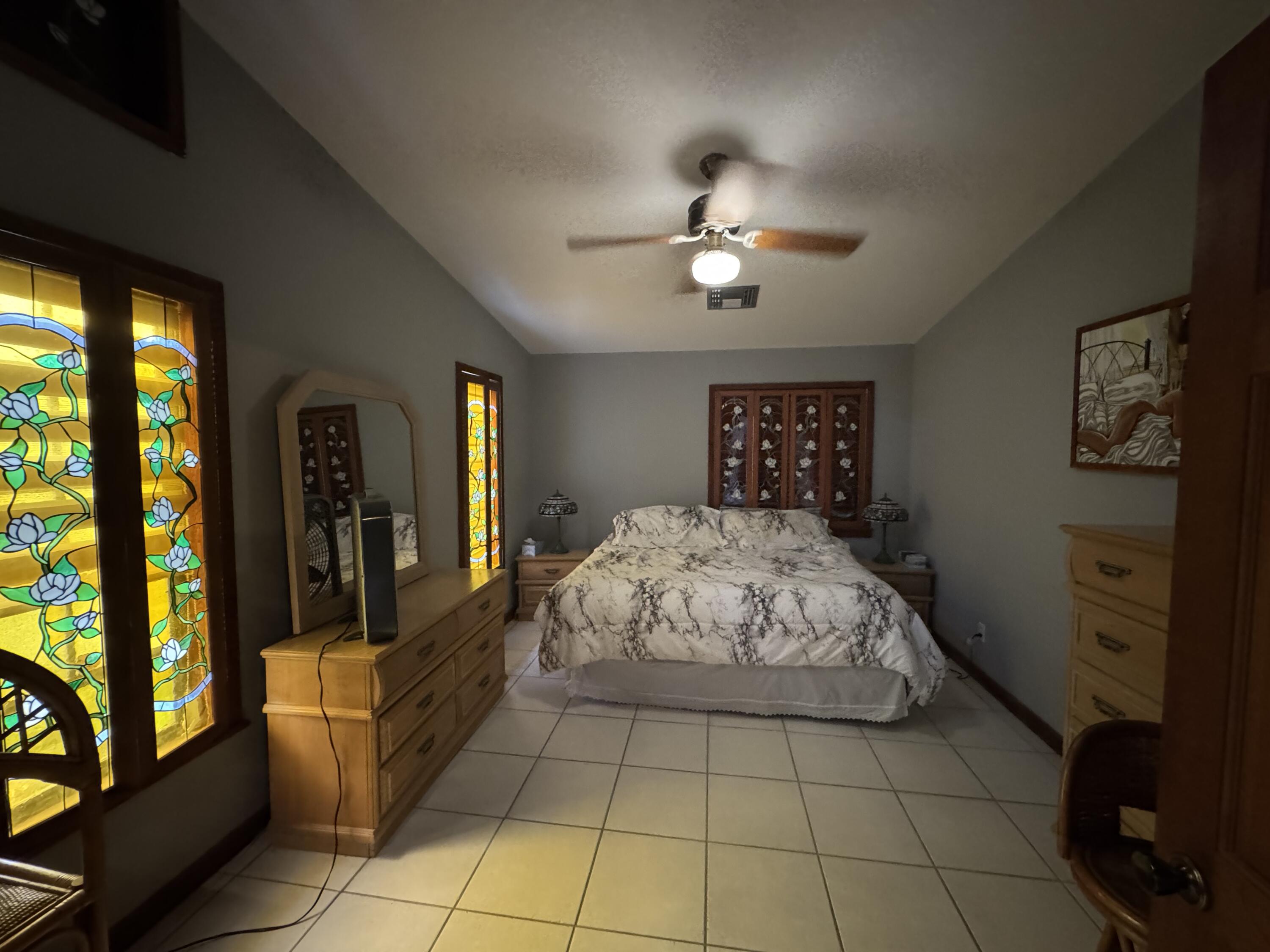 22970 Sharp Lane Cudjoe, FL 33042 - Photo 16 of 45 a spacious bedroom with a large bed and a chandelier