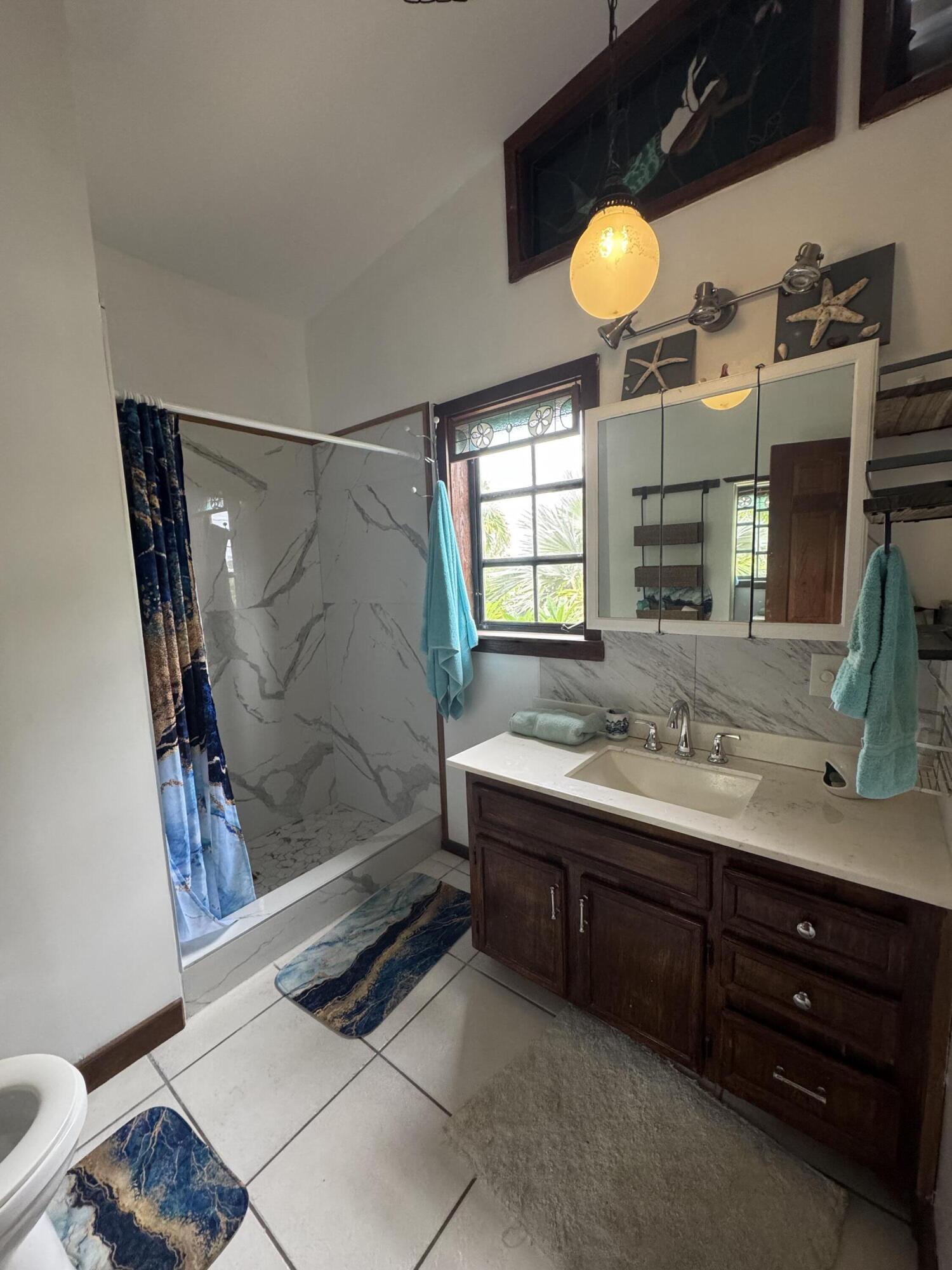 22970 Sharp Lane Cudjoe, FL 33042 - Photo 17 of 45 a bathroom with a sink and a mirror