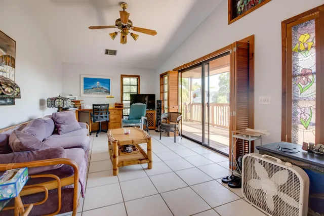 a living room with furniture a flat screen tv and a large window