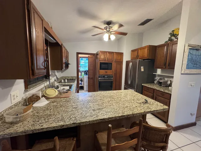 a kitchen with granite countertop stainless steel appliances and wooden cabinets