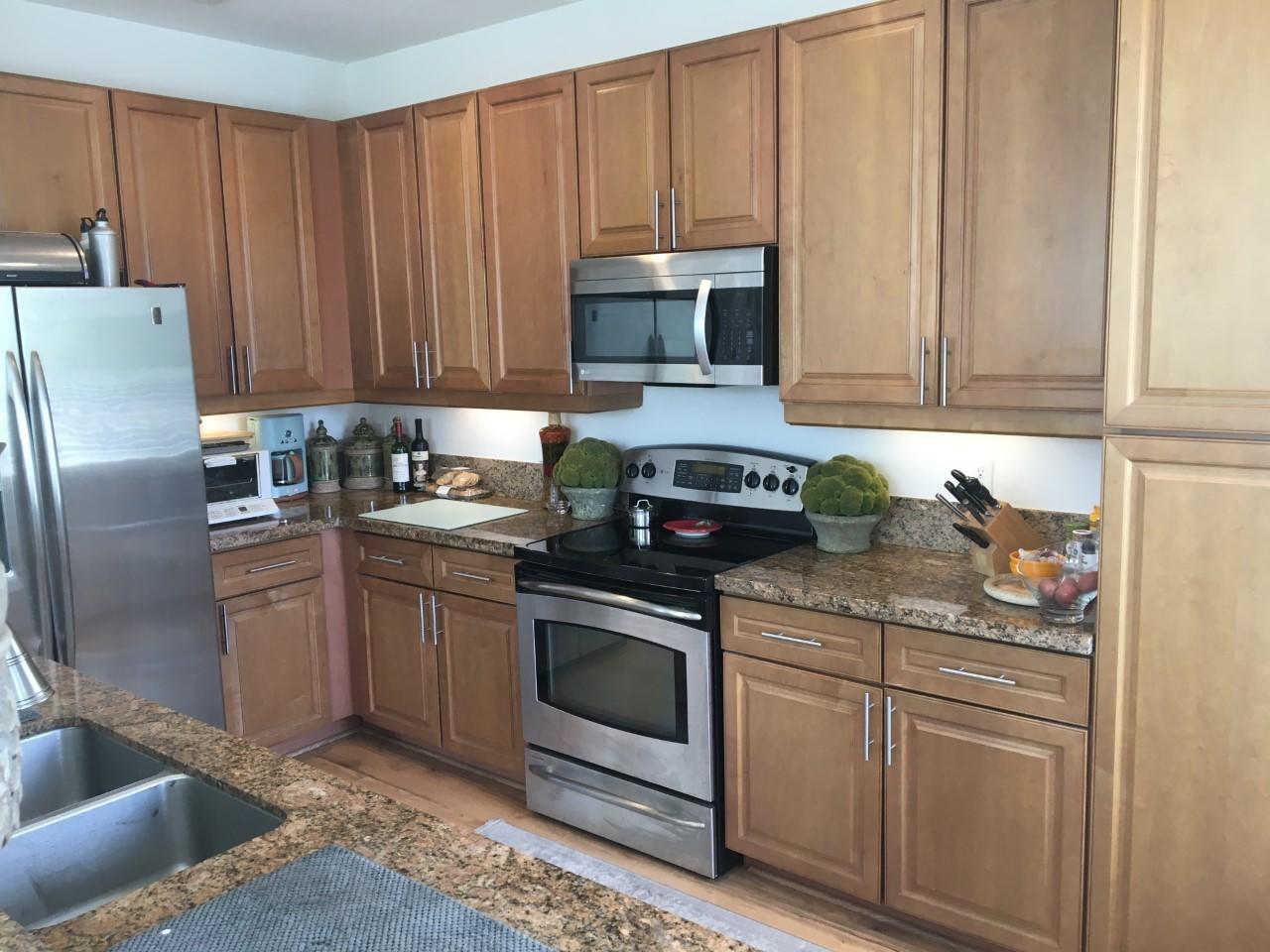 555 Northwest 35th Place Boca Raton, FL 33431 - Photo 14 of 43 a kitchen with stainless steel appliances granite countertop a refrigerator a stove a sink and white cabinets