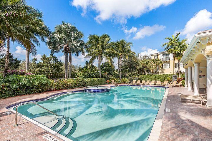 555 Northwest 35th Place Boca Raton, FL 33431 - Photo 40 of 43 a view of a swimming pool with a lawn chairs under palm trees