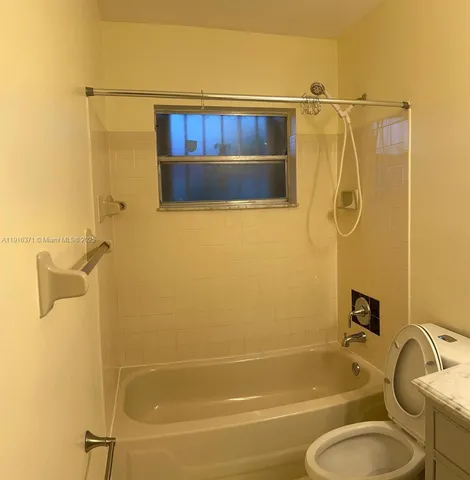 a bathroom with a granite countertop sink toilet and a mirror
