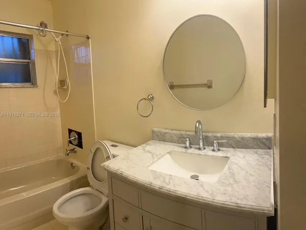 a bathroom with a granite countertop sink toilet and a mirror