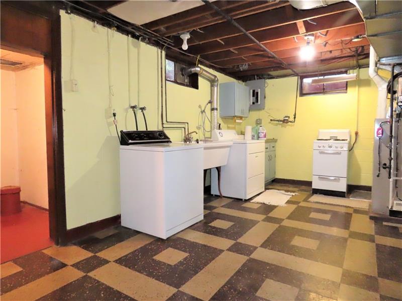 675 Davidson Drive Rochester, PA 15074 - Photo 21 of 25 Laundry area has a large storage room, electrical breaker box, small gas stove, electric dryer and washer plus the newer furnace and hot water tank