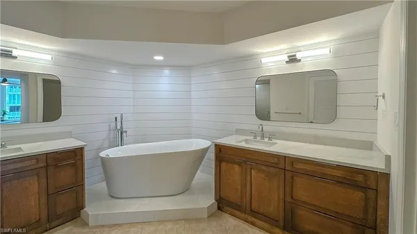 a spacious bathroom with a granite countertop sink mirror and a shower
