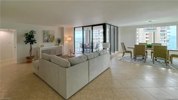 a living room with furniture and potted plants with wooden floor