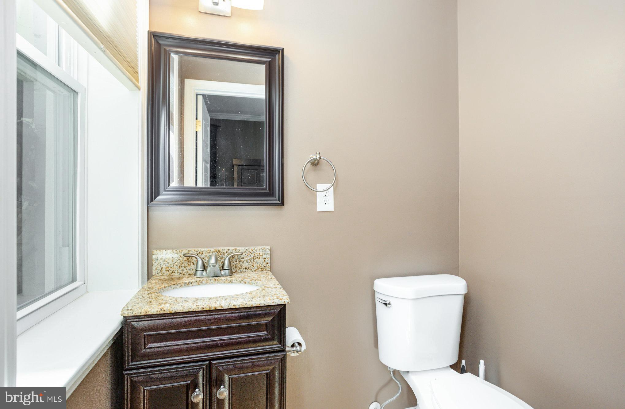 3515 Gough Street Baltimore, MD 21224 - Photo 14 of 27 a bathroom with a toilet a sink and mirror