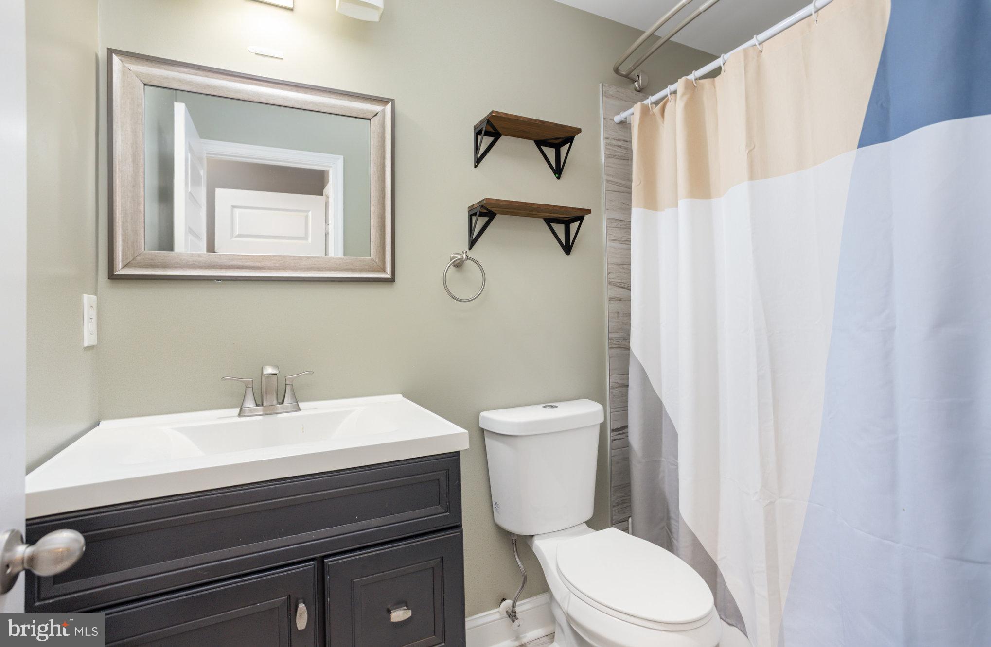 3515 Gough Street Baltimore, MD 21224 - Photo 17 of 27 a bathroom with a sink mirror and toilet