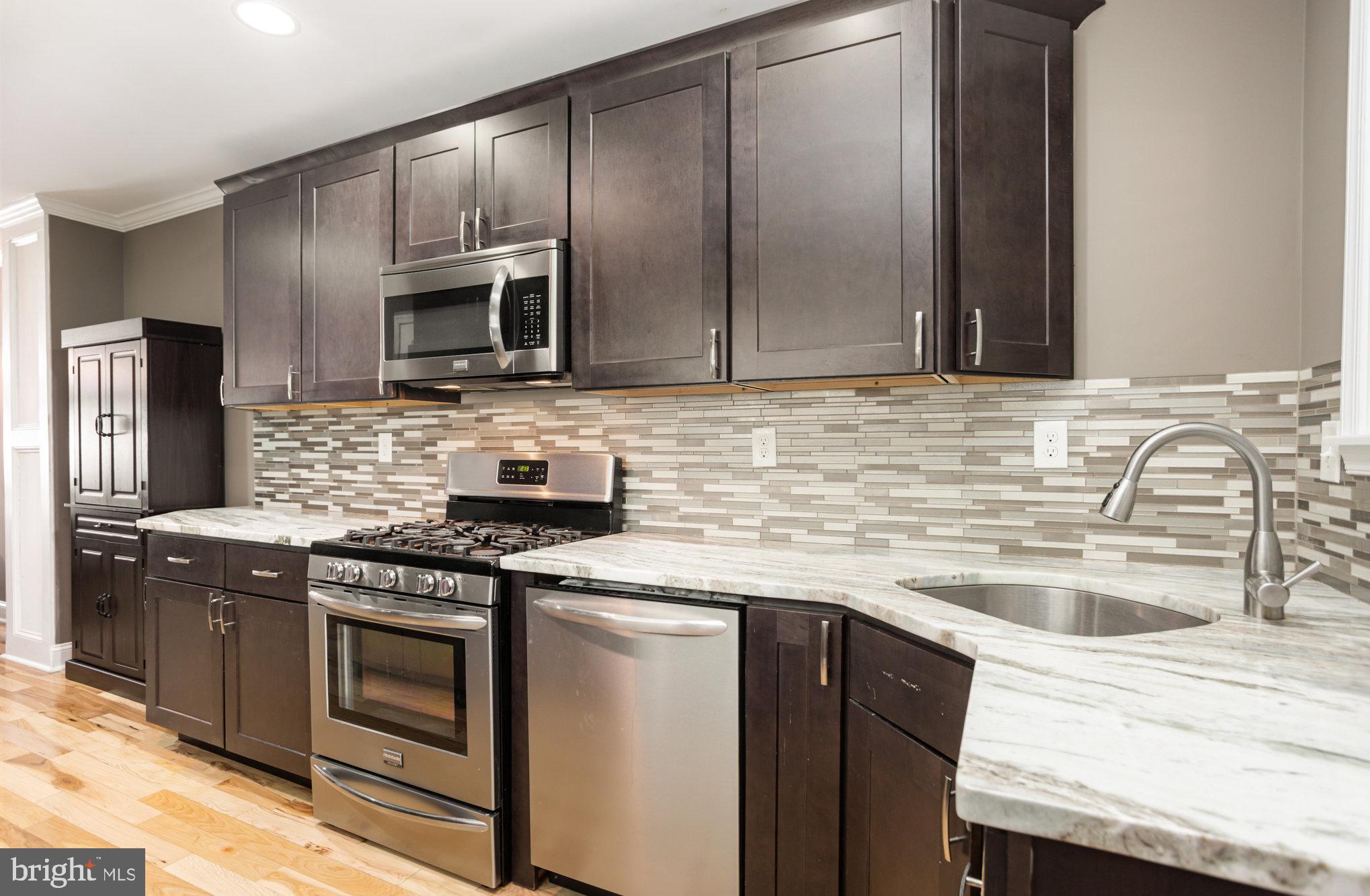 3515 Gough Street Baltimore, MD 21224 - Photo 9 of 27 a kitchen with kitchen island granite countertop a sink stainless steel appliances and cabinets