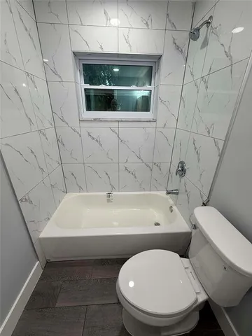 an empty room with wooden floor and mirror