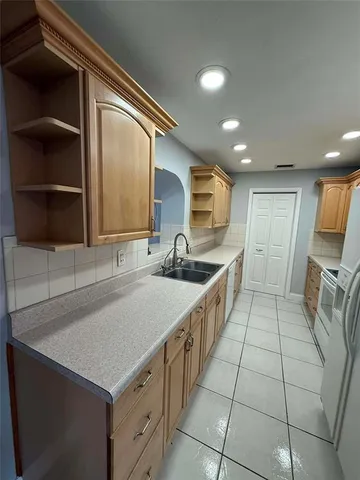 a kitchen with granite countertop a refrigerator and a sink