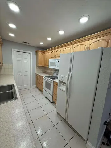 a kitchen with white cabinets and white appliances