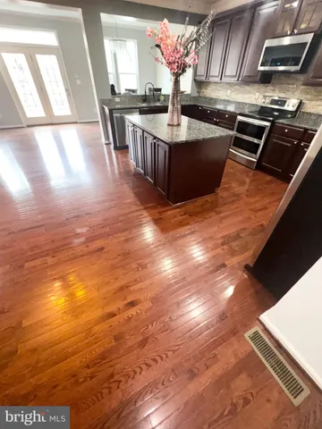 a view of kitchen with stainless steel appliances wooden floor