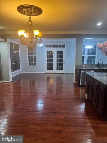 a view of a room with chandelier and wooden floor