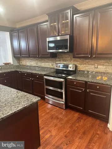 a kitchen with granite countertop stainless steel appliances and wooden cabinets