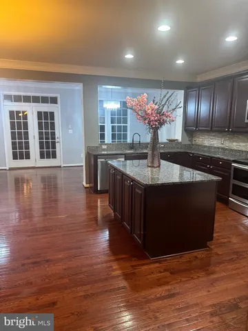 a kitchen with stainless steel appliances granite countertop a coffee table and chairs