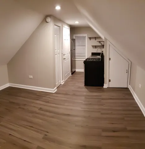 a view of a kitchen with wooden floor and a refrigerator