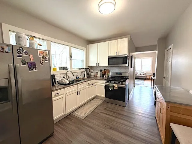 a kitchen with granite countertop a refrigerator stove top oven and sink
