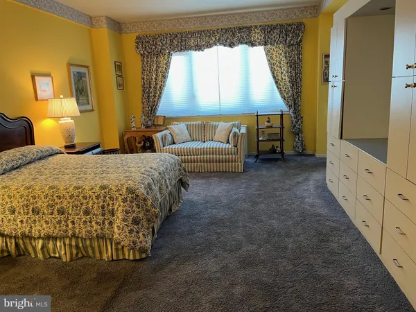 a spacious bedroom with a bed and a window