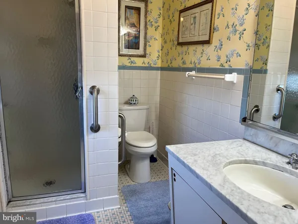 a bathroom with a granite countertop toilet sink and mirror