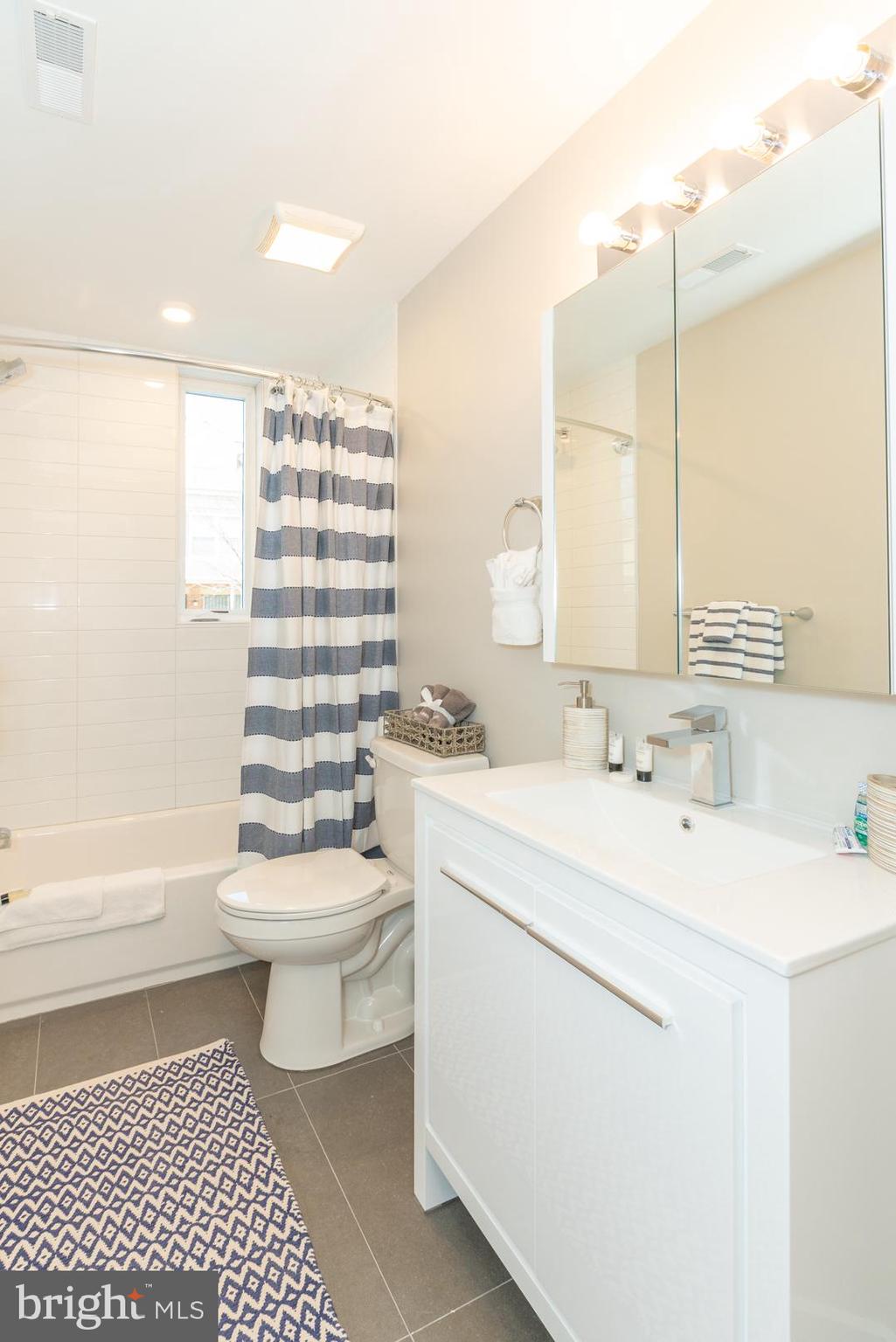 2220-28 Master Street, Unit 1 Philadelphia, PA 19121 - Photo 10 of 14 a bathroom with a sink toilet vanity and tub