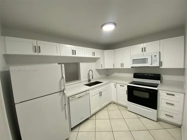 a kitchen with cabinets stainless steel appliances and a sink