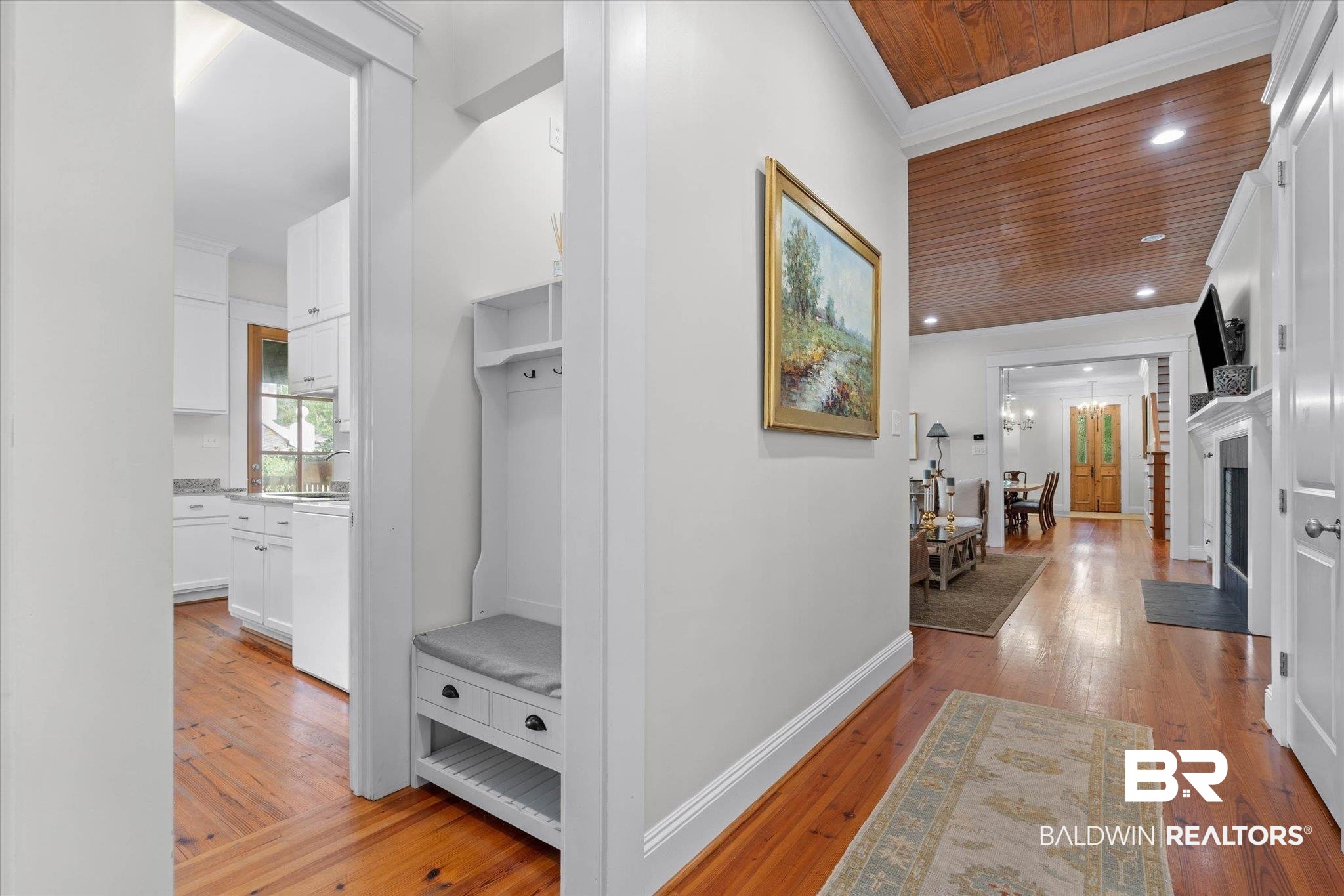 3813 Austill Lane Mobile, AL 36608 - Photo 11 of 37 Hardwood flooring throughout the main hallway, featuring a built-in hall tree with seating and storage
