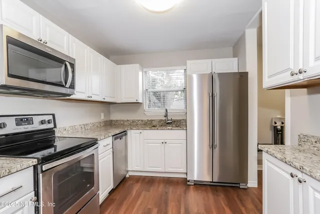 a kitchen with stainless steel appliances granite countertop a refrigerator stove top oven and sink