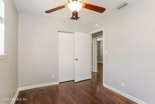 a view of an empty room with wooden floor