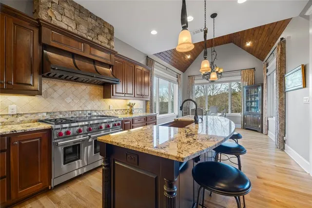 a kitchen with stainless steel appliances granite countertop a sink stove and cabinets