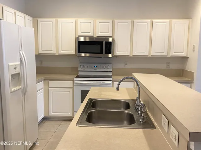 a kitchen with a sink a microwave and cabinets