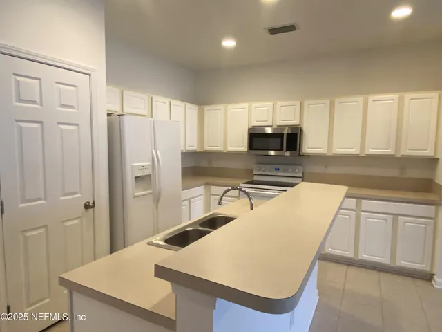 a kitchen with refrigerator and cabinets