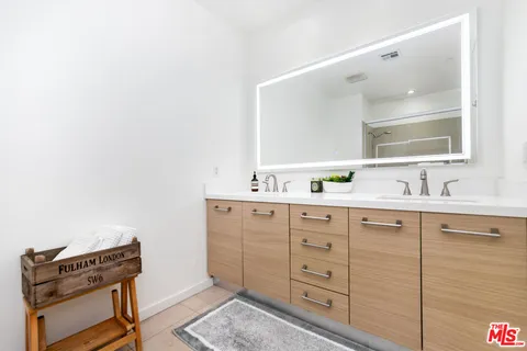 a spacious bathroom with a double vanity sink a mirror and a