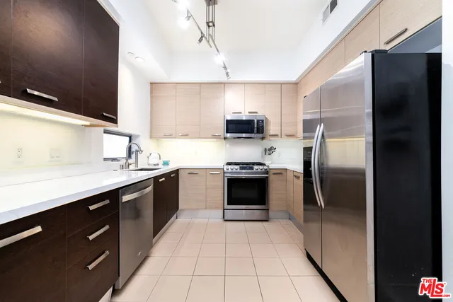 a kitchen with a sink stainless steel appliances and cabinets