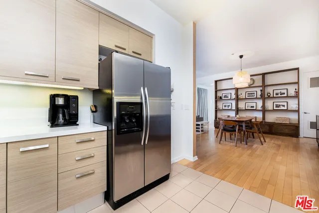 a kitchen with granite countertop a refrigerator and a stove top oven