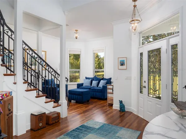 a living room with furniture potted plant kitchen view and a window