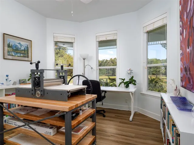 a living room with furniture potted plant kitchen view and a window
