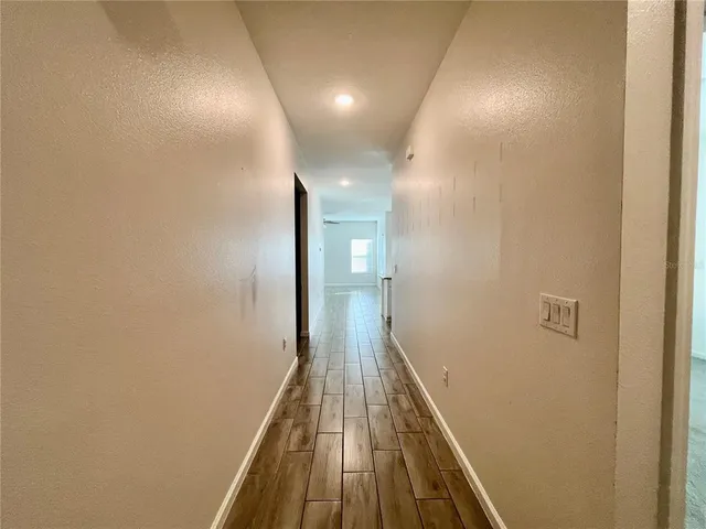 a view of a hallway with wooden floor
