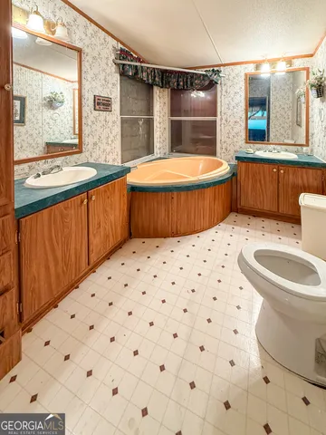 a spacious bathroom with a granite countertop sink and a mirror