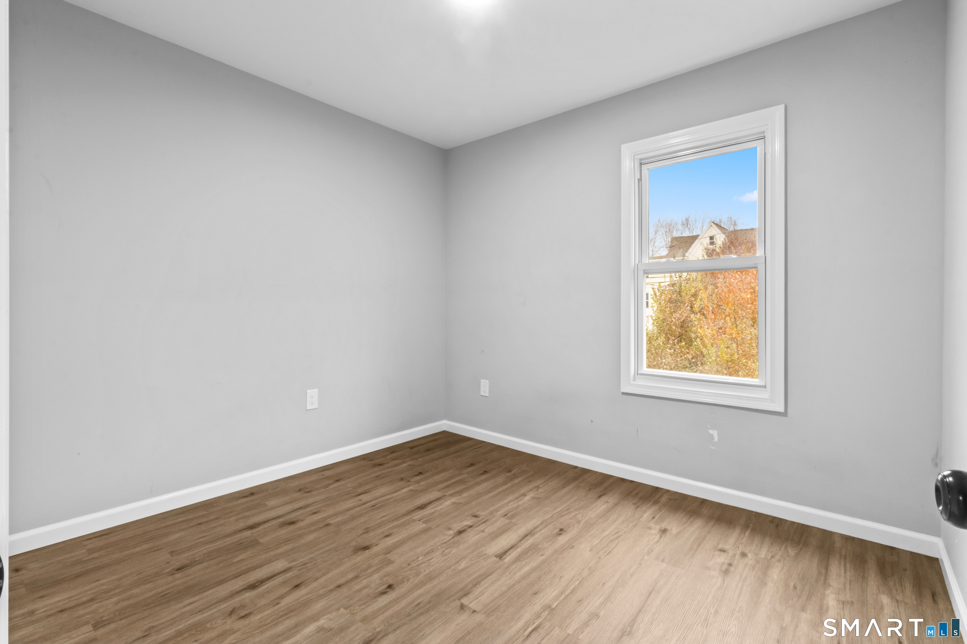 173 Shaw Street New London, CT 06320 - Photo 11 of 19 a view of an empty room with wooden floor and a window