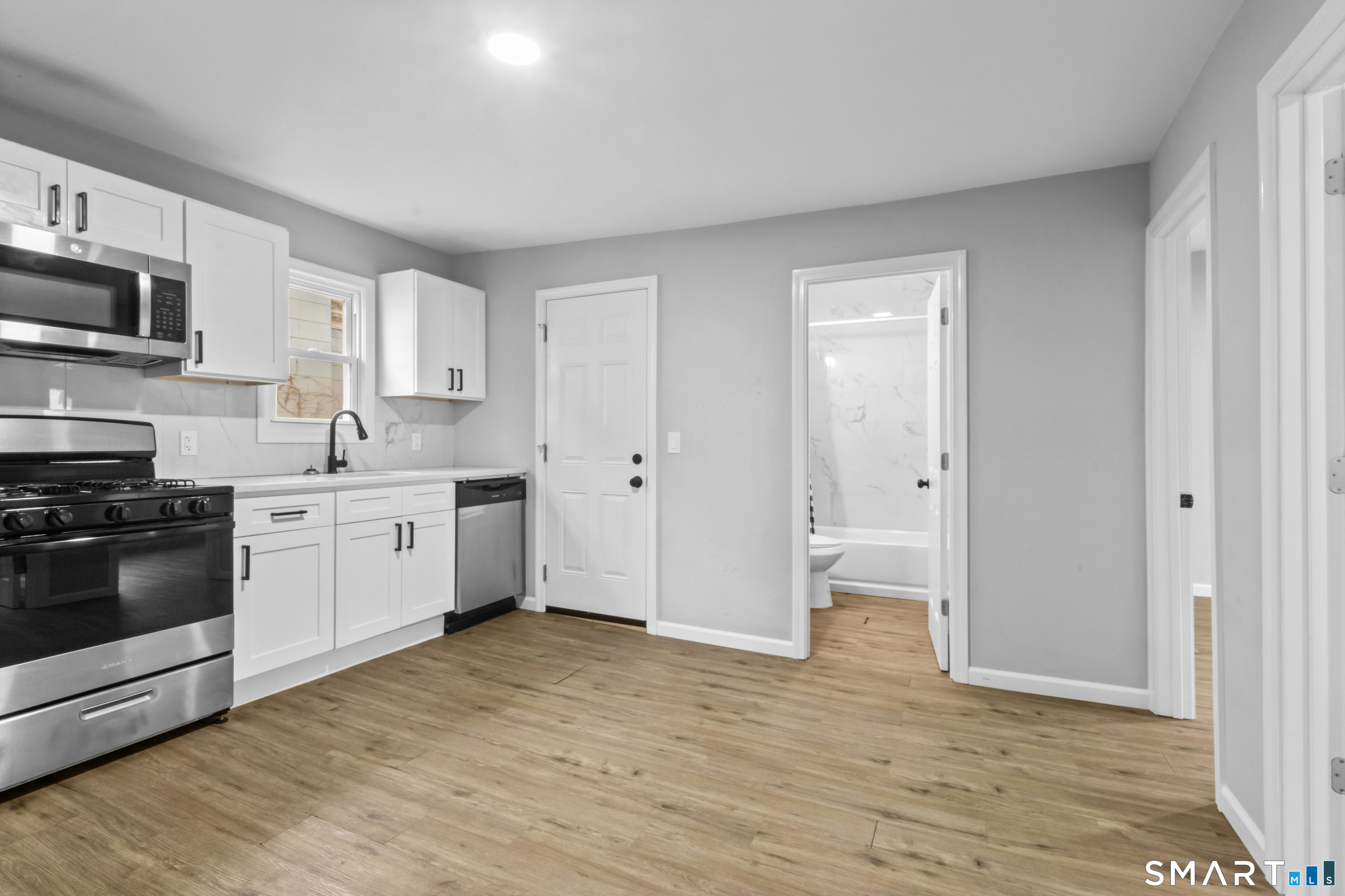173 Shaw Street New London, CT 06320 - Photo 7 of 19 a kitchen with a white cabinets and white appliances