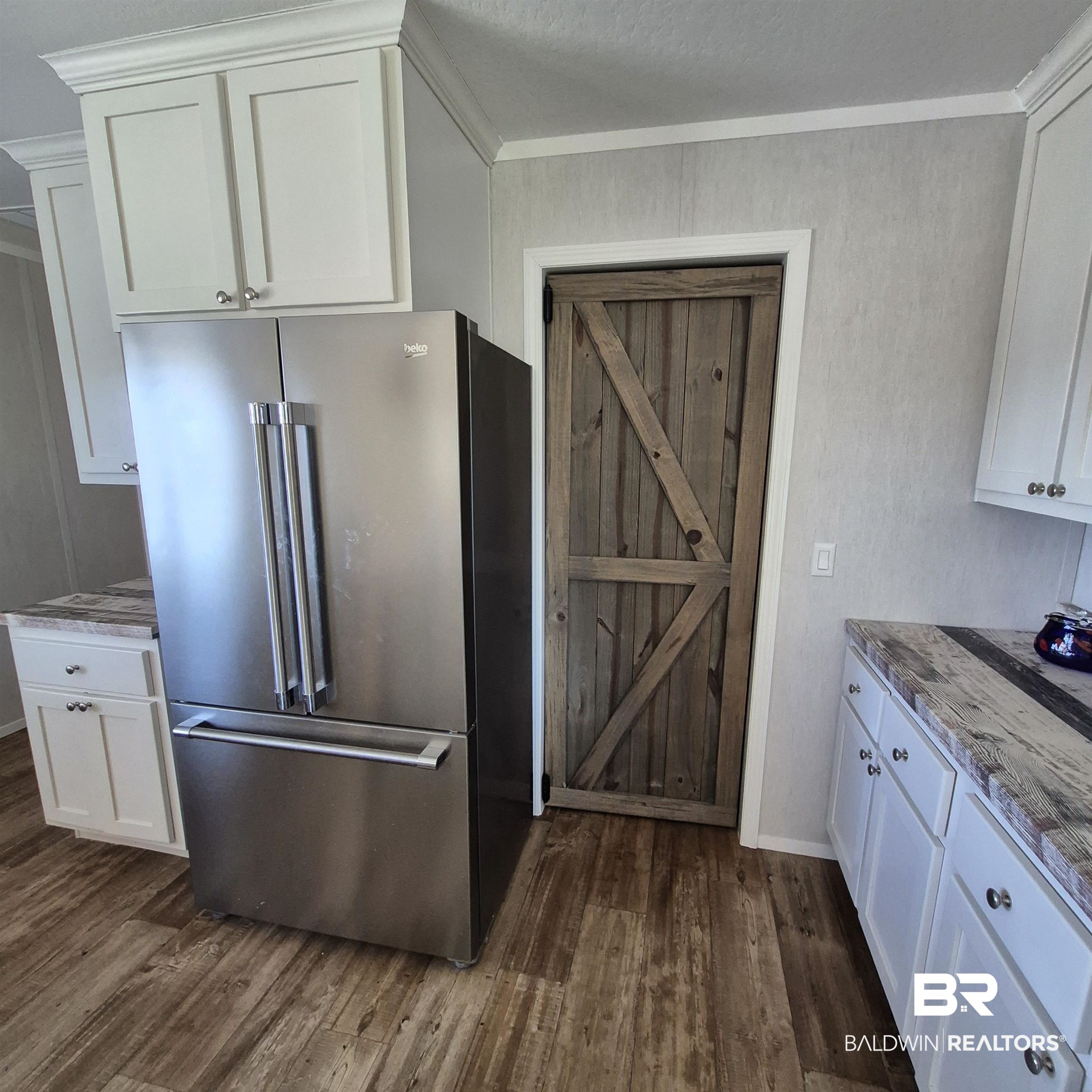 8867 Old Stage Road Repton, AL 36475 - Photo 11 of 37 Kitchen featuring white cabinetry, high quality fridge, ornamental molding, dark wood-style flooring, and light stone counters