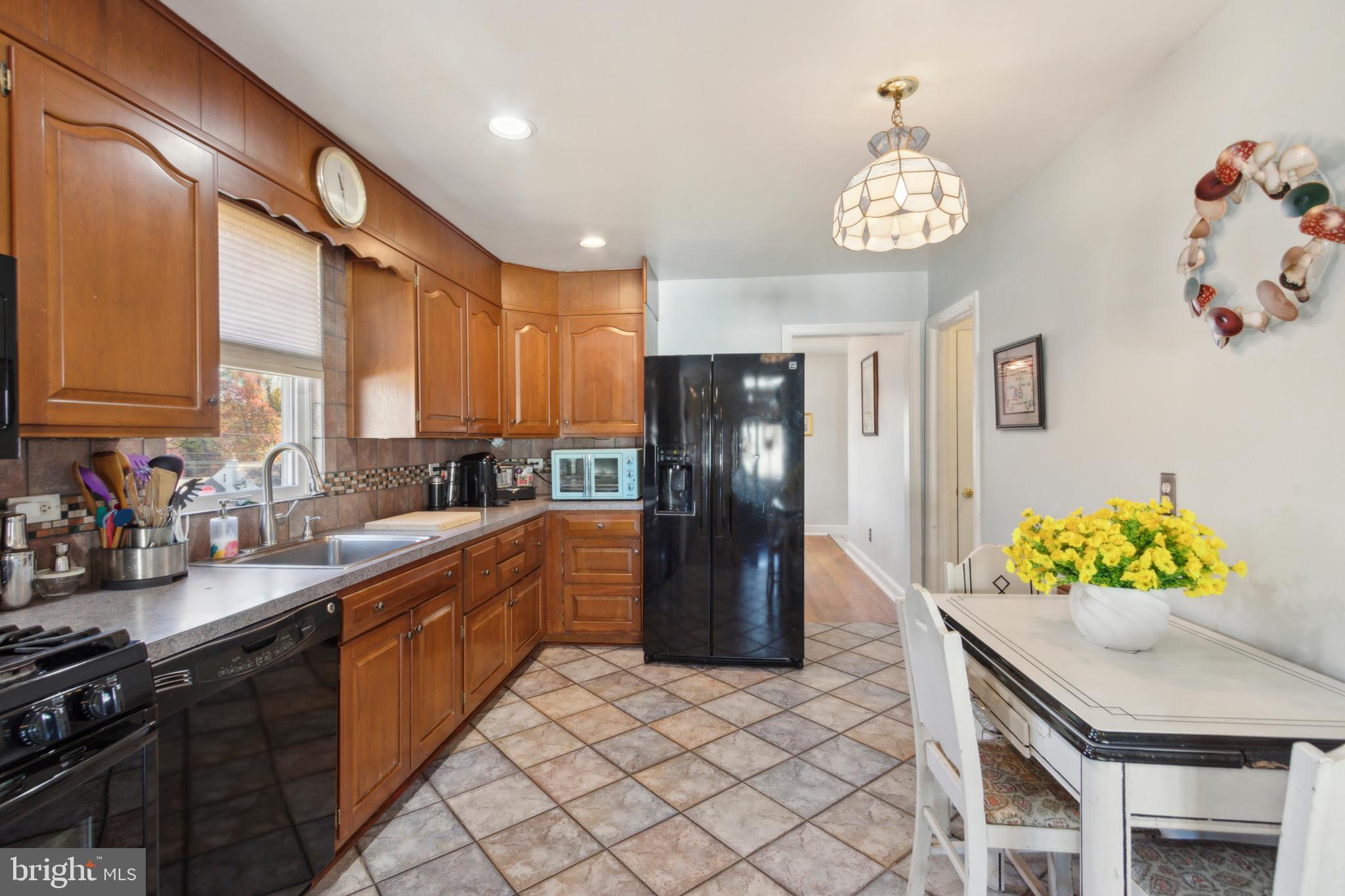 408 Barker Road Springfield, PA 19064 - Photo 13 of 22 a kitchen with stainless steel appliances granite countertop a sink a stove cabinets and a dining table